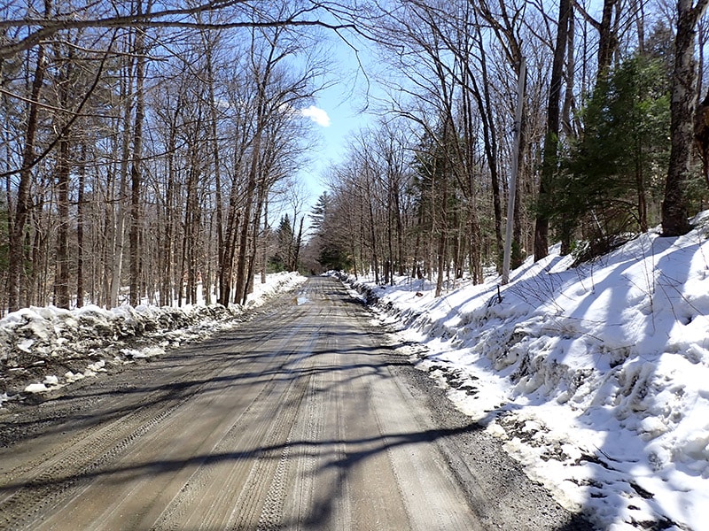 town road access through snowy property in early Spring